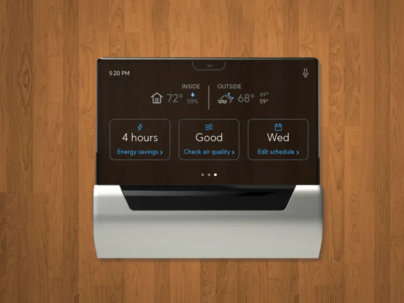 GLAS mounted on a wood-paneled wall, home screen showing energy savings, air quality, and schedule cards